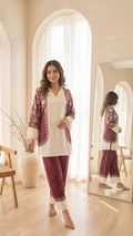 Woman in a matching outfit standing in a room with a mirror.