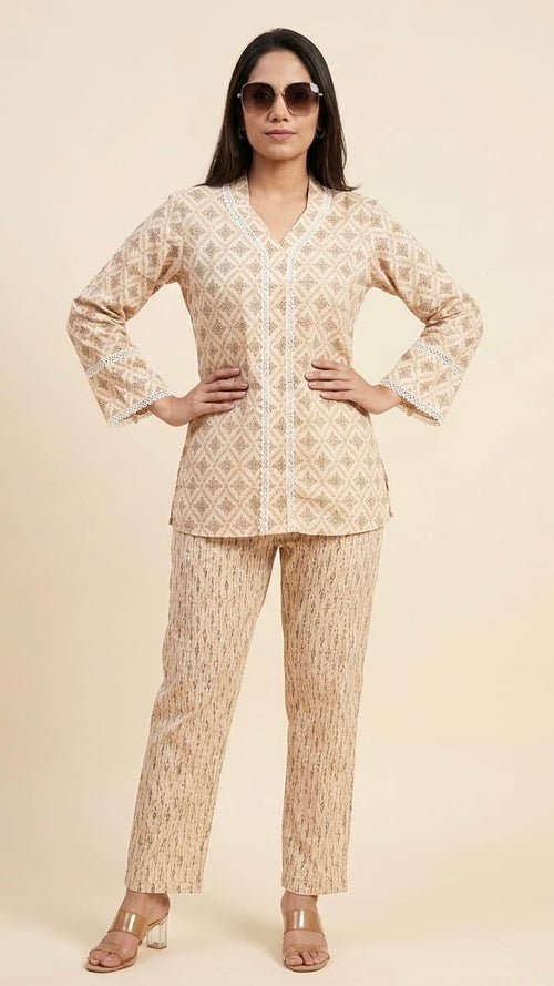 Woman wearing a beige patterned outfit on a plain background