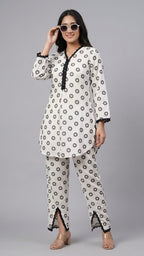 Woman wearing a polka dot kurta with matching pants on a gray background