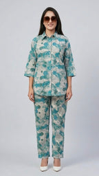 Woman wearing a teal and gray patterned outfit on a white background