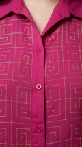 Close-up of a pink shirt with gold geometric pattern