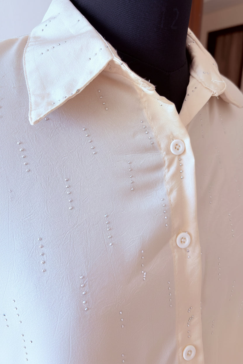 Close-up of a white shirt with buttons and a collar, partially visible.