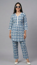 Woman wearing a blue and white patterned kurta with matching pants on a gray background