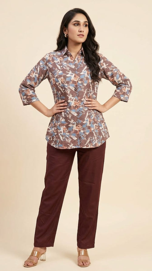 Woman wearing a floral blouse and maroon pants on a beige background