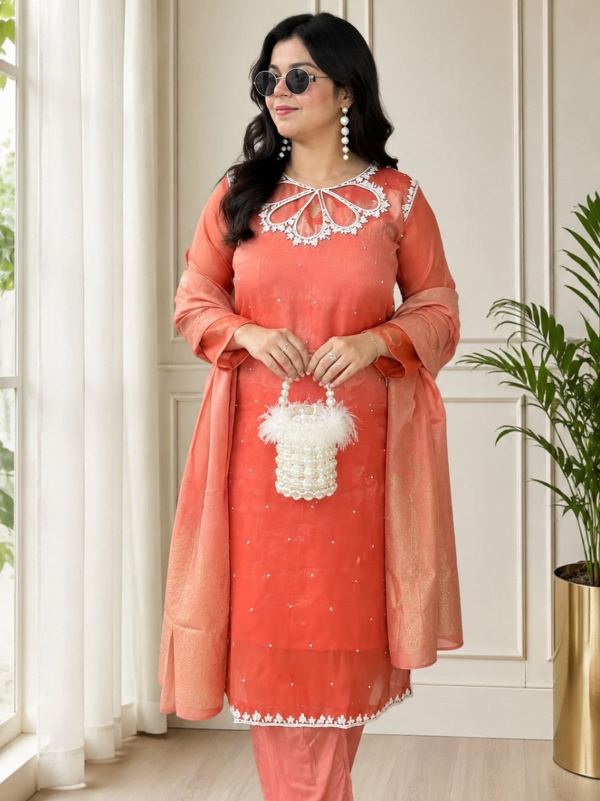 Woman wearing coral embroidered kurta set with dupatta by Kivoz Kira Lifestyles